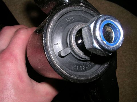 1996 Ford Probe - A hand holds a car's suspension component, showing a bolt and nut assembly with visible part numbers.
