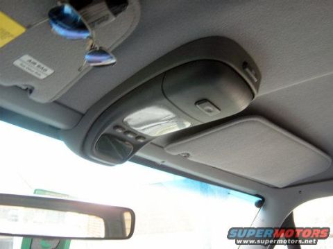 1986 Ford Bronco - The interior of a vehicle shows the overhead console and a sun visor with an airbag warning label.