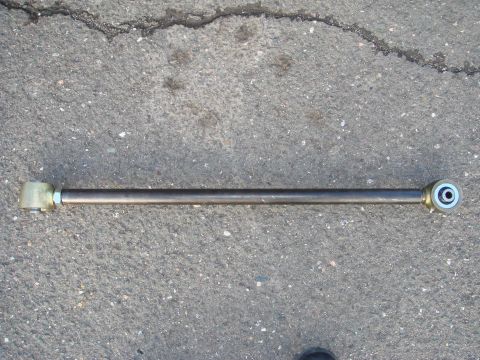 1996 Ford Bronco - A single track bar, a suspension component, is shown lying on a cracked asphalt surface.