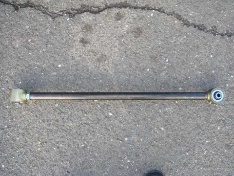 1996 Ford Bronco - An adjustable track bar is shown lying on a textured asphalt surface.