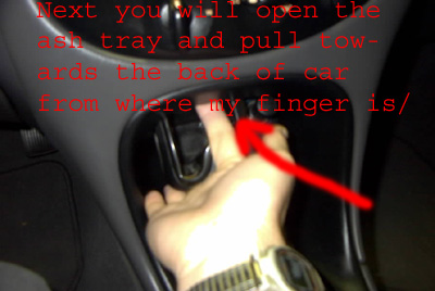 1999 Ford Taurus - A hand is shown reaching into the center console of a car's interior.