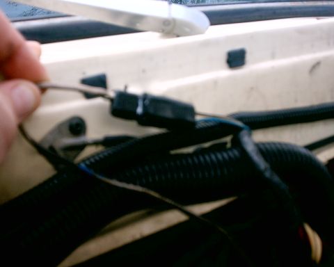 1979 Ford Bronco - Close-up view of a vehicle's engine wiring harness, with a hand manipulating a wire.