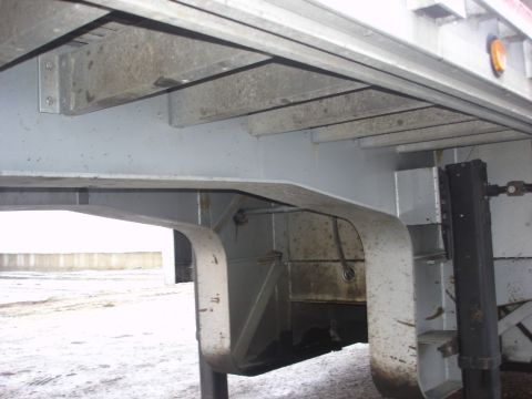 2006 Ford F-350 - The underside of a trailer is shown, revealing its structural components and a deployed jack.