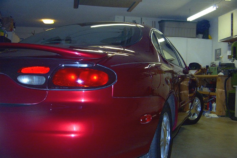Red 1999 Ford Taurus sedan, rear quarter view, parked indoors