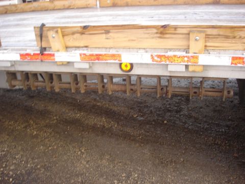 2006 Ford F-350 - Close-up view of a trailer's hitch mechanism, multiple metal rods and a yellow marker light.