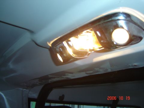 1993 Ford Bronco - The interior dome light fixture is illuminated, showing chrome accents and the headliner.