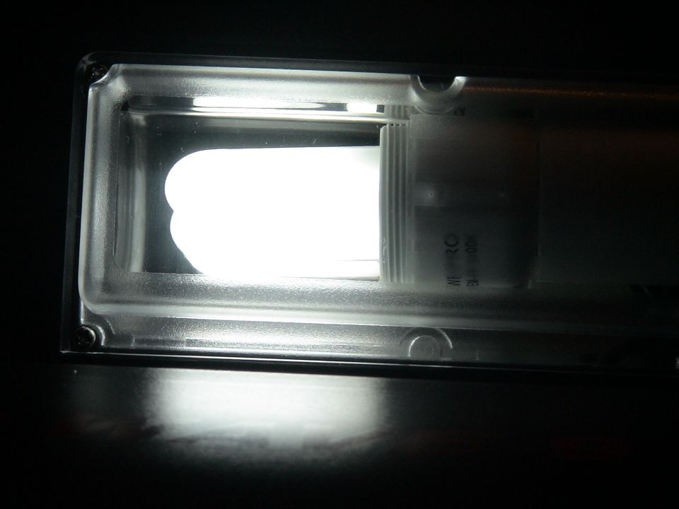 Illuminated rectangular light fixture glowing bright white in the dark