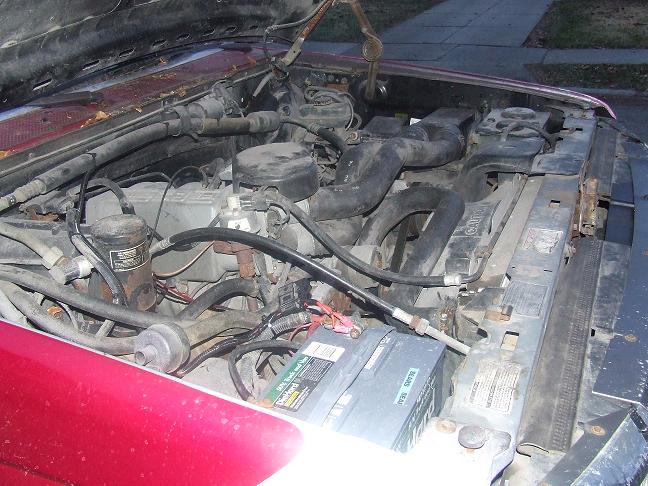 1992 Ford Bronco engine bay with hood open, showing engine components and battery