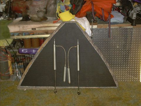 1978 Ford Bronco - Two shock absorbers and two springs are displayed on a triangular board in a workshop setting.