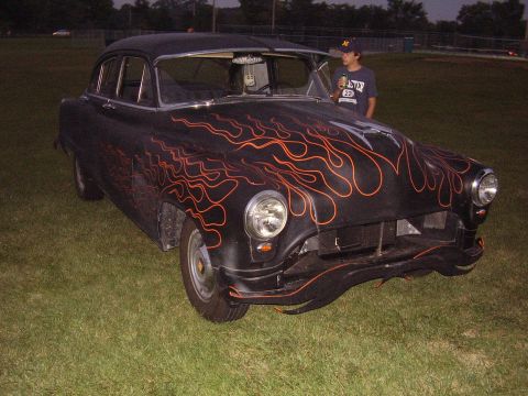 1996 Ford F-150 - A black sedan with custom orange flame decals is viewed from the front quarter angle on a grassy field.