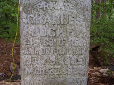 1996 Ford F-150 - A weathered gravestone stands in a forest, bearing the inscription of a name and dates.
