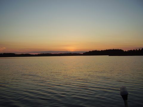 1996 Ford F-150 - A lake scene at sunset, with the sky painted in hues of orange and blue, and a treeline visible on the horizon.