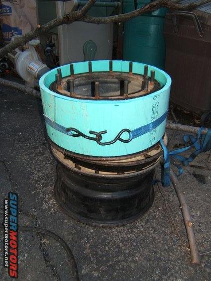 1980 Jeep CJ5 - A custom-made part, possibly for a vehicle, is assembled on stacked wheel rims outdoors.