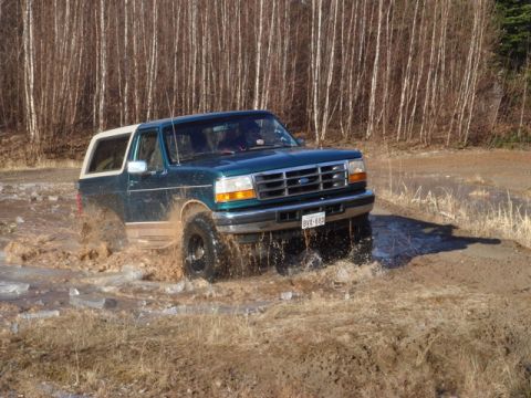 1996 Ford Bronco - This 1996 Ford Bronco navigates a muddy and icy terrain, kicking up water and dirt.