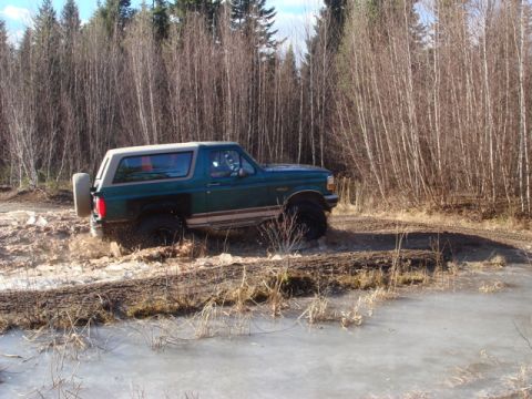 1996 Ford Bronco - Ford Bronco navigates a challenging off-road course with mud and ice.