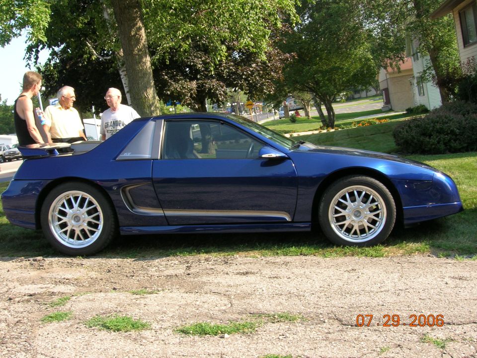 Blue sports car side view with custom wheels