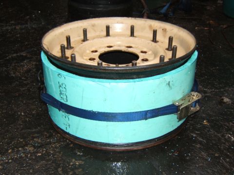 1980 Jeep CJ5 - Brake drum assembly with shoes secured by a strap and ratchet mechanism.