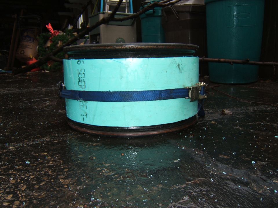 close-up of a vehicle wheel rim with blue strapping around a light blue cylinder