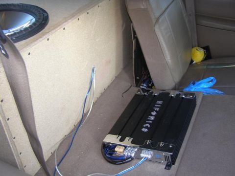 1998 Mercury Mountaineer - The interior of a vehicle displays custom audio equipment including a subwoofer box and amplifier.