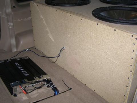 1998 Mercury Mountaineer - The rear interior of a vehicle shows a custom subwoofer enclosure and an audio amplifier with wiring.