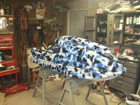 1995 Ford Mustang - A jet ski with a unique camouflage paint scheme is displayed in a cluttered garage setting.