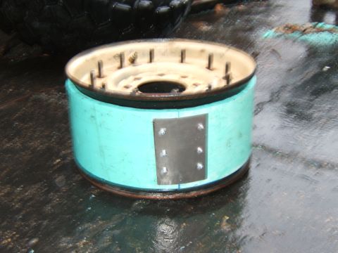 1980 Jeep CJ5 - Close-up of a brake drum assembly, showing its turquoise painted exterior and metal components.