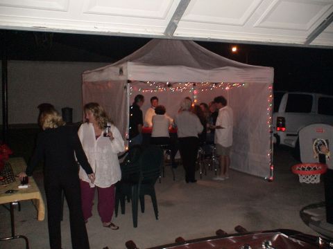 1993 Ford C-350 (Centurion Conversions) - A white SUV is parked outside a tent decorated with lights, with people gathered inside.