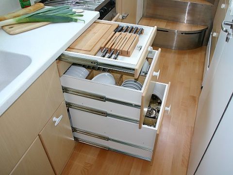 1993 Ford Bronco - Interior view of a kitchen area with organized drawers and a sink, showing food preparation items.