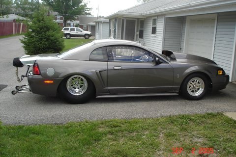 1990 Ford Mustang - This modified drag car features a prominent hood scoop and a large rear spoiler, indicating performance modifications.