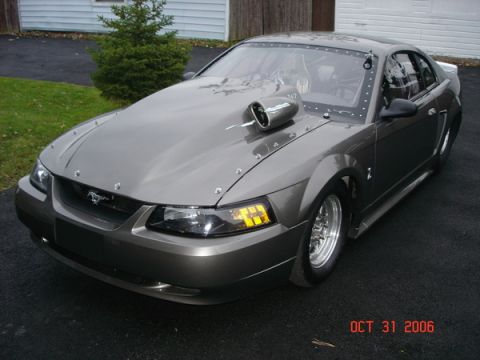 1990 Ford Mustang - This heavily modified Mustang features a prominent hood scoop and racing slicks, indicating it's built for performance.
