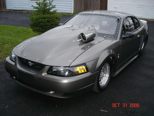 Gray custom Mustang with hood scoop and drag racing tires