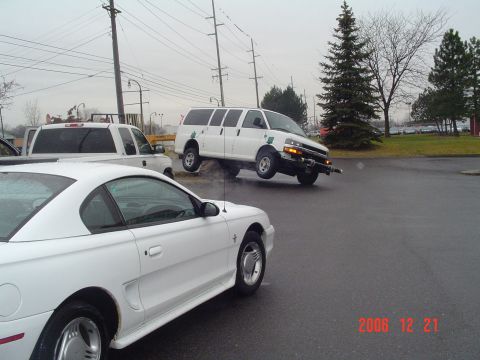 1992 Ford Bronco - A white van is shown driving off-road, with its front wheels lifted.