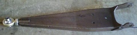 1984 Ford Bronco - A single control arm with a heim joint is shown against a concrete background.