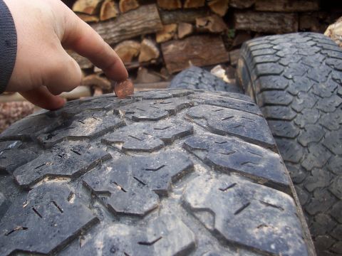 1994 Jeep YJ - Tire tread depth is checked using a penny, indicating the amount of wear on the tire.