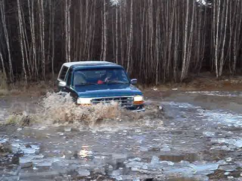1996 Ford Bronco - A 1996 Ford Bronco navigates through a watery and icy terrain, kicking up a large splash.
