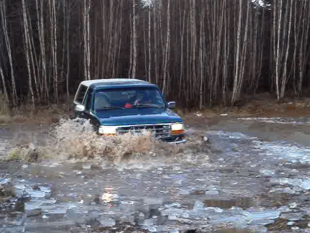 1996 Ford Bronco driving through water and ice, 3q-front view
