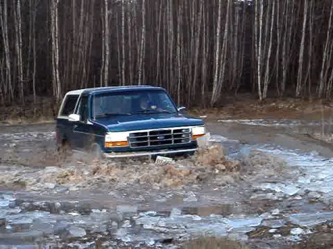 1996 Ford Bronco - This Ford Bronco is navigating a challenging off-road terrain with water and ice.