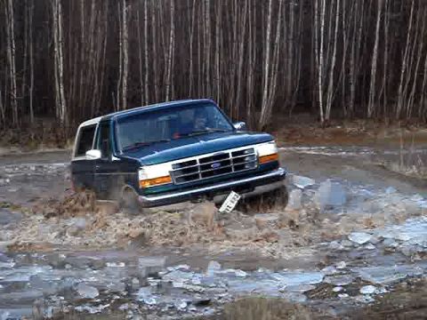 1996 Ford Bronco - This 1996 Ford Bronco is navigating a challenging off-road path with water and ice.