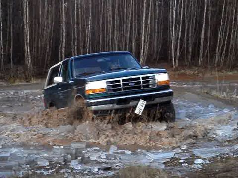 1996 Ford Bronco - 1996 Ford Bronco navigating a muddy off-road trail.