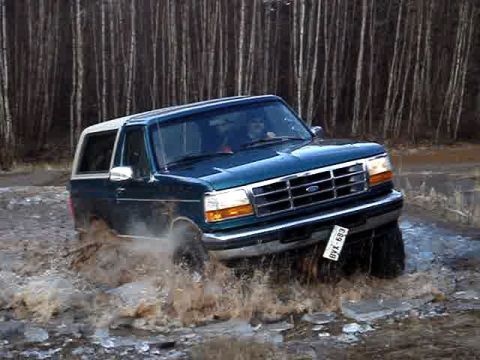 1996 Ford Bronco - This 1996 Ford Bronco is navigating through a water-filled path, kicking up spray.