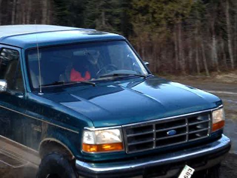 1996 Ford Bronco - Front 3/4 view of a teal 1996 Ford Bronco on a dirt road.