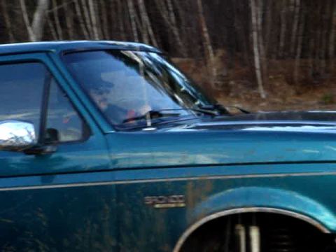 1996 Ford Bronco - Side profile of a teal 1996 Ford Bronco, showing the 'BRONCO' badge on the fender.