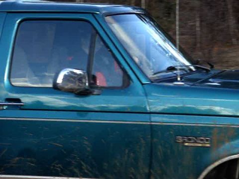 1996 Ford Bronco - The side panel of a teal Ford Bronco shows the 'BRONCO' emblem.