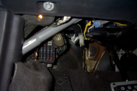 1994 Dodge Stealth - Close-up view of a vehicle's interior wiring harness and fuse box, with visible electrical components and metal supports.