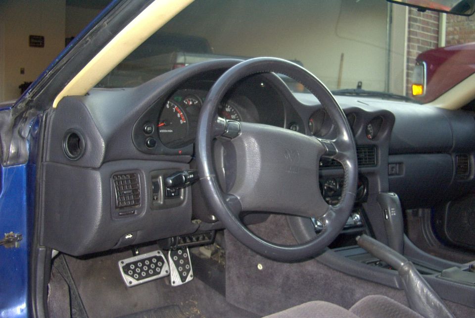 Interior of a 1994 Dodge Stealth showing dashboard, steering wheel, and pedals