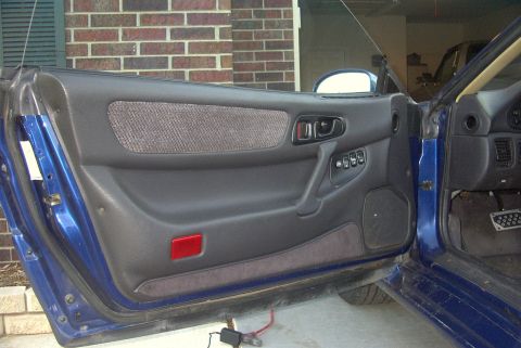 1994 Dodge Stealth - Interior view of a 1994 Dodge Stealth's blue door panel, showing the power window controls and speaker.