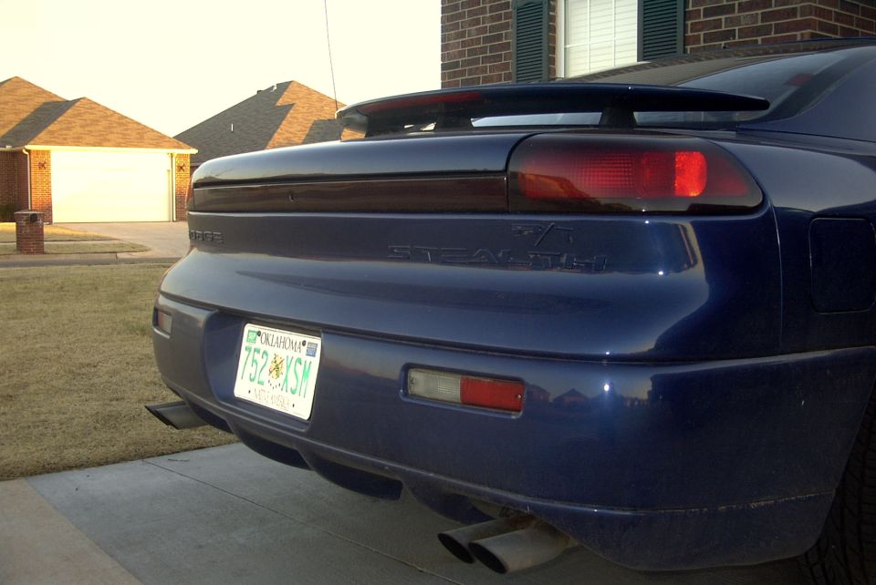Blue 1994 Dodge Stealth rear view with spoiler and dual exhaust pipes