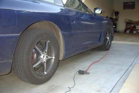 1994 Dodge Stealth - Side profile of a blue 1994 Dodge Stealth, parked indoors with a red cord running near the rear tire.