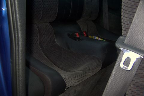 1994 Dodge Stealth - Interior view of a car's rear seats with visible seatbelt mechanisms and fabric upholstery.