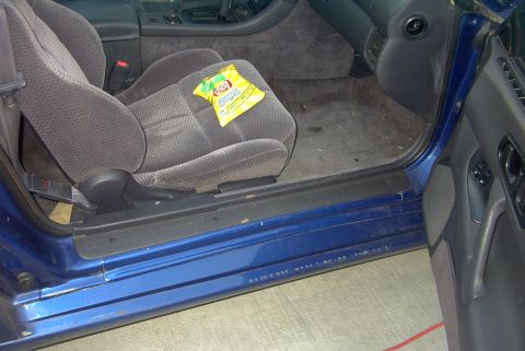 1994 Dodge Stealth - Interior view of a car's passenger side, with a bag of chips resting on the seat.